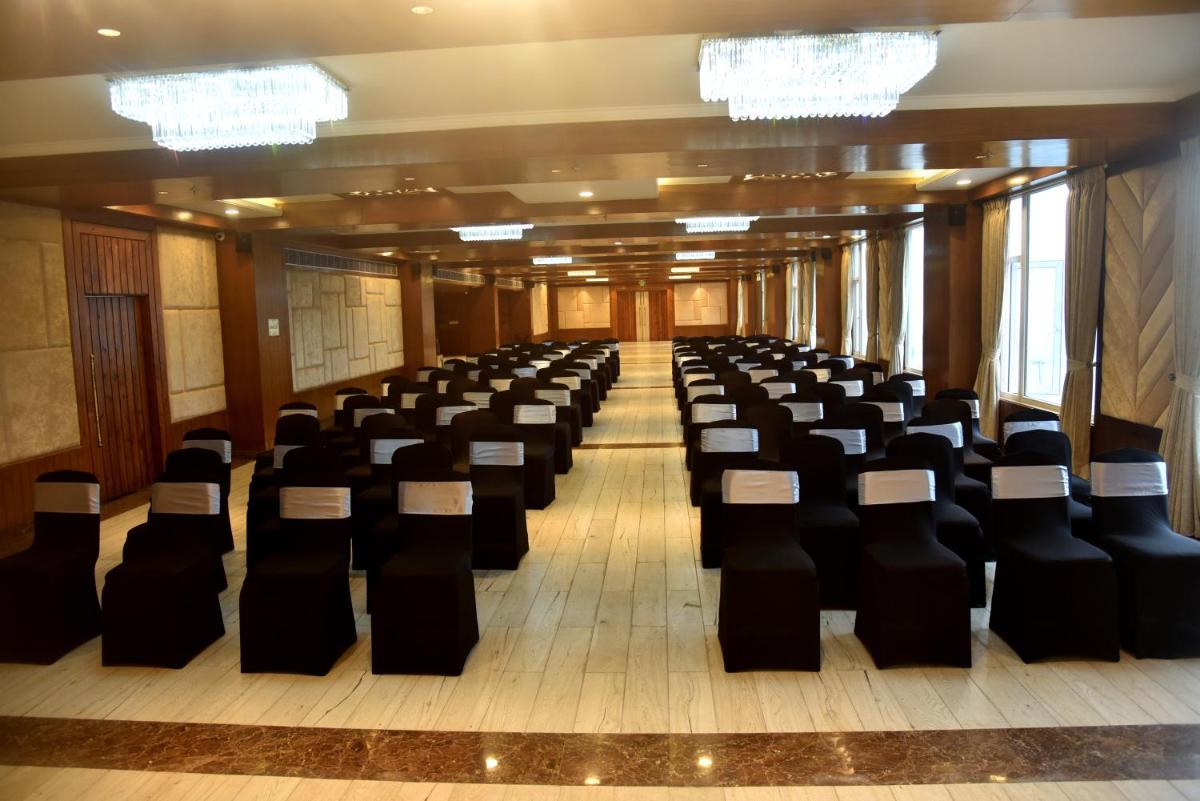 a row of chairs in a large room with chandeliers at The Orchid Shimla in Shimla