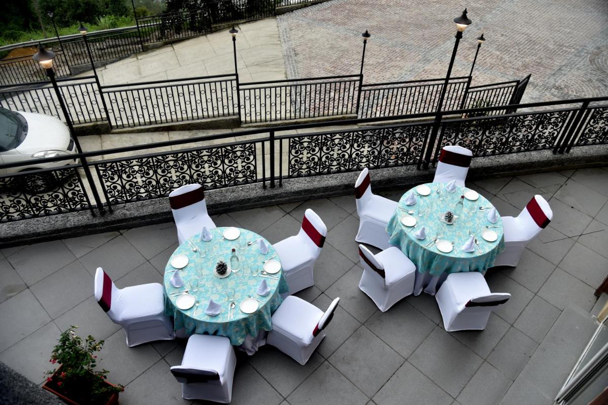 an overhead view of a table with white chairs and a blue table andasteryastery at The Orchid Shimla in Shimla