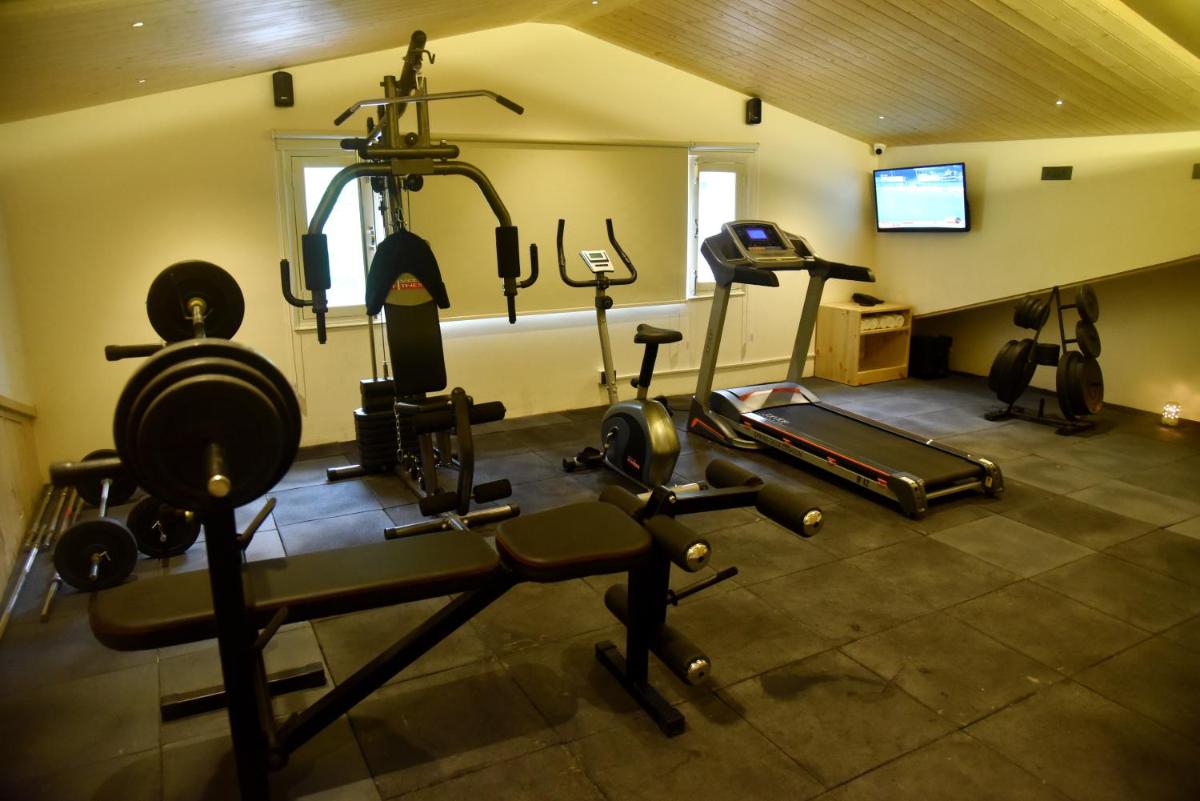 a gym with several exercise equipment in a room at The Orchid Shimla in Shimla
