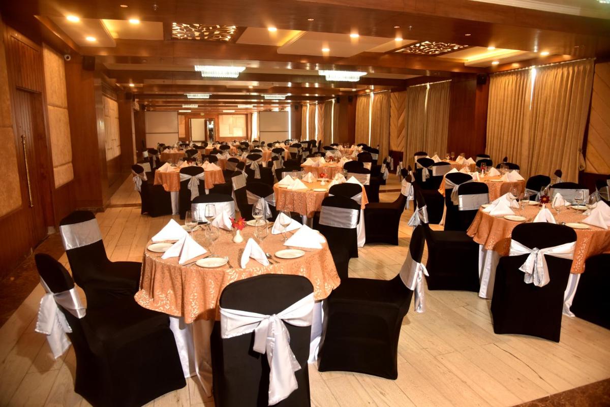 a banquet hall filled with tables and chairs with tablesktop at The Orchid Shimla in Shimla