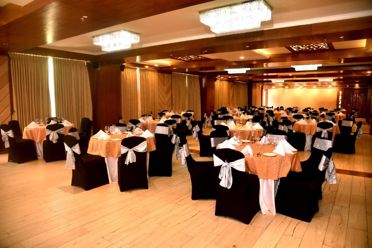 a banquet hall filled with tables and chairs at The Orchid Shimla in Shimla