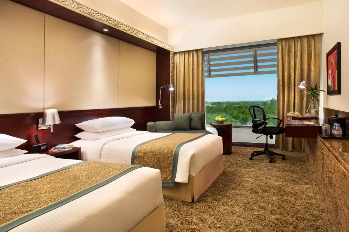 a hotel room with two beds and a window at Crowne Plaza Ahmedabad City Centre by IHG in Ahmedabad