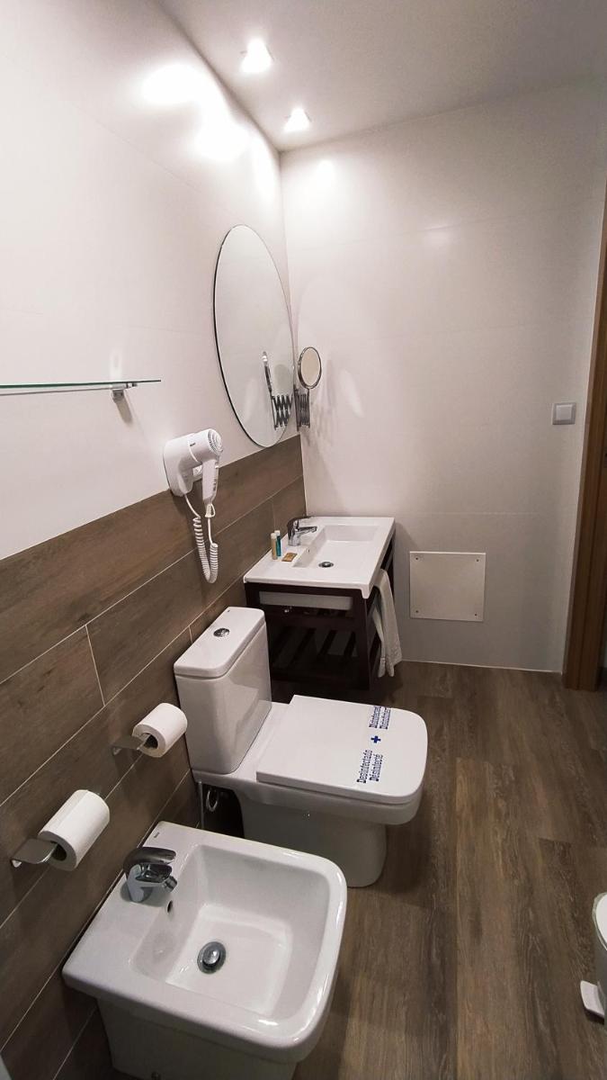 Un baño con un inodoro blanco y un lavabo. en Hotel Balneario El Raposo, en Puebla de Sancho Pérez
