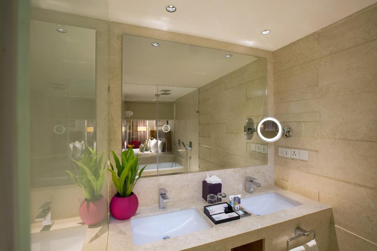 a bathroom with two sinks and a large mirror at Mercure Hyderabad KCP Banjara Hills, An Accor Hotel in Hyderabad