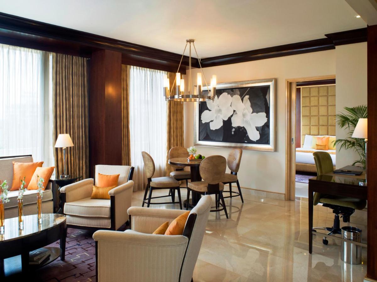a living room with a piano and a dining room at Blue Diamond Pune IHCL SeleQtions in Pune