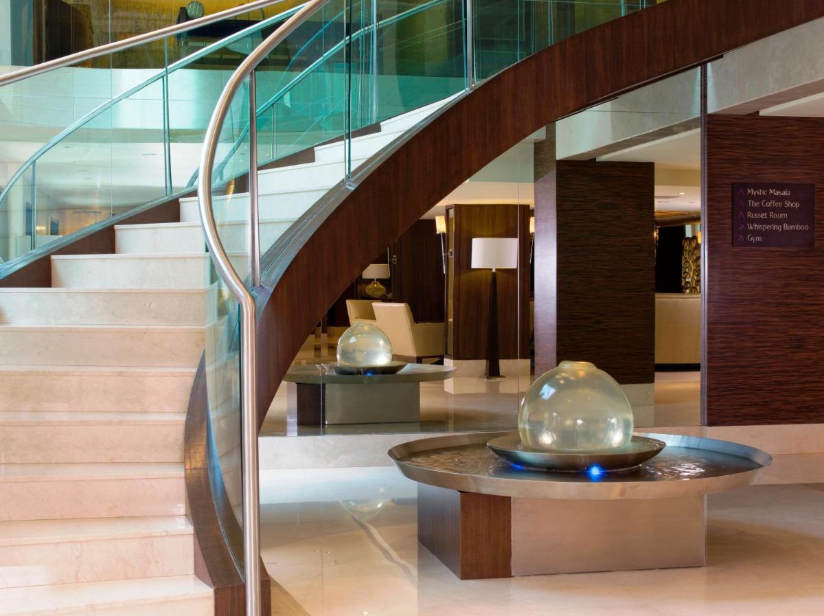 a staircase in a building with a glass stair case at Blue Diamond Pune IHCL SeleQtions in Pune
