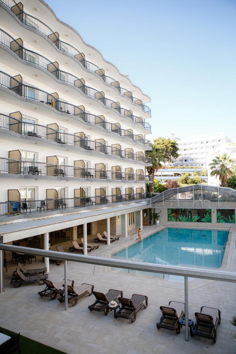 Un gran edificio con una piscina en frente. en Hotel Helios Lloret, en Lloret de Mar