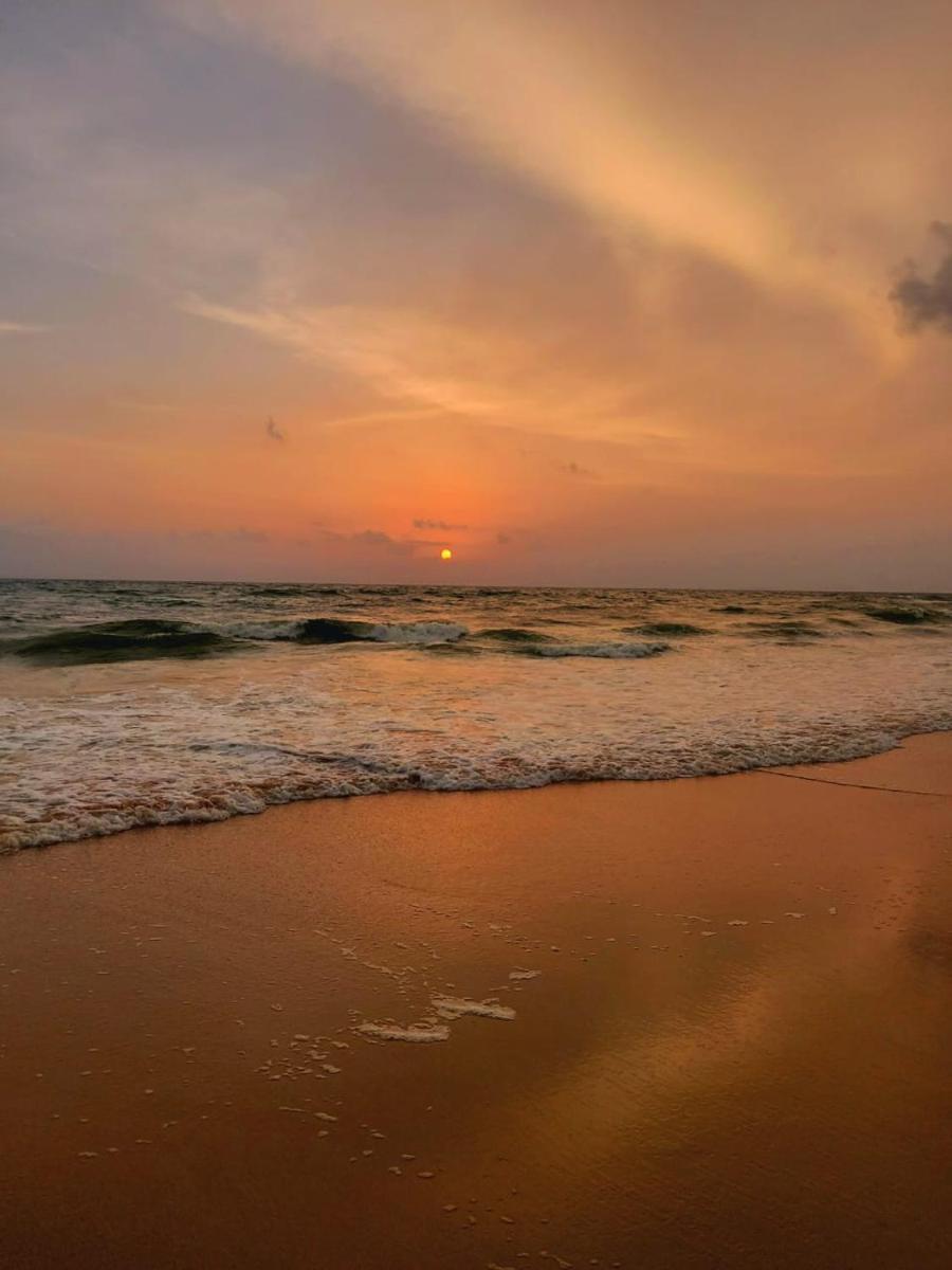 a sunset on the beach with the ocean at Holiday Inn Goa Candolim in Candolim a sunset on the beach with the ocean at Holiday Inn Goa Candolim in Candolim