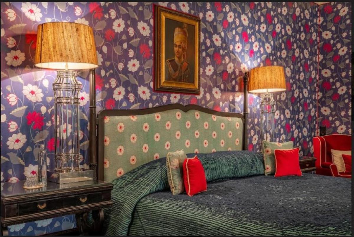 a bedroom with a bed with red pillows on it at Rajmahal Palace RAAS in Jaipur