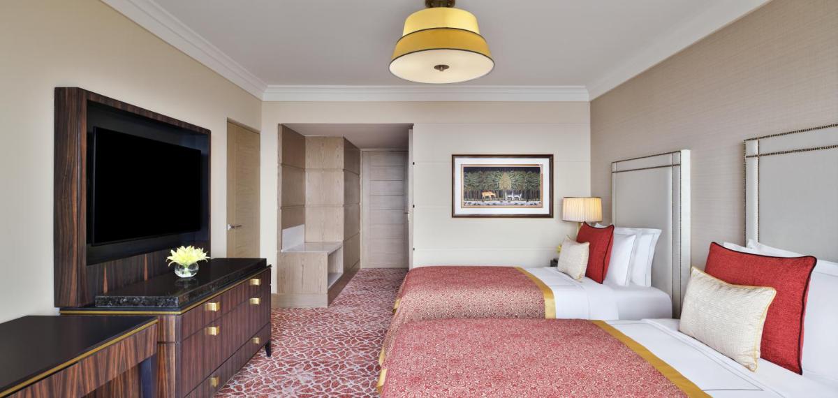 a hotel room with a bed and a flat screen tv at Taj Mahal, New Delhi in New Delhi