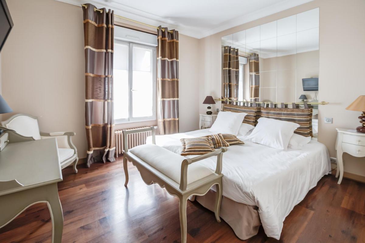 une chambre avec un grand lit blanc et un bureau dans l'établissement Hostellerie de la Renaissance, à Argentan