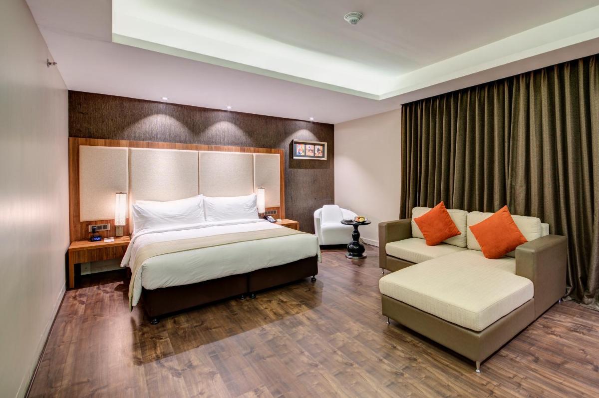 a hotel room with a bed and a couch at Holiday Inn Kolkata Airport by IHG in Kolkata