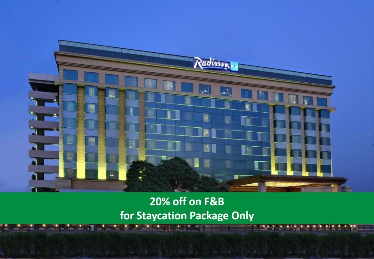 a building with a sign on top of it at Radisson Blu Jaipur in Jaipur