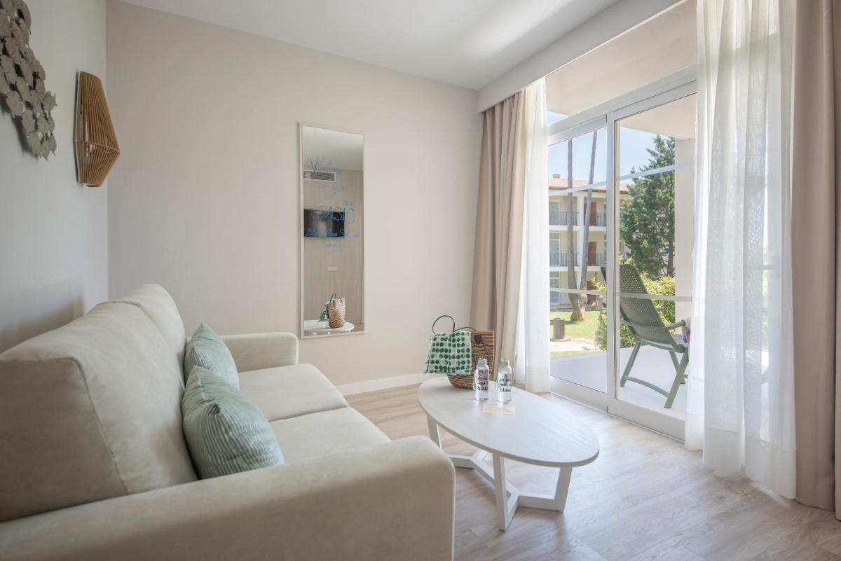 Una sala de estar blanca con un sofá y una mesa. en Blau Colònia Sant Jordi, en Colonia de Sant Jordi
