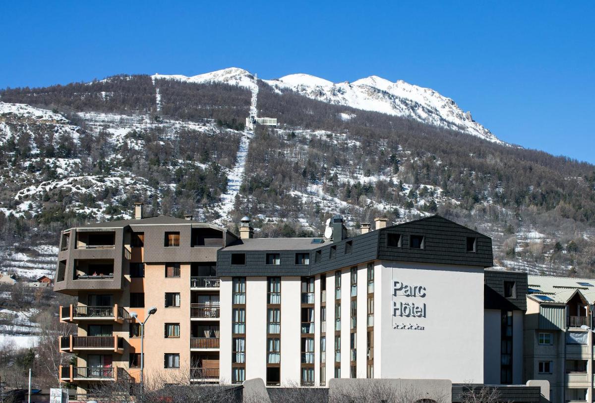 un hôtel en face d'une montagne enneigée dans l'établissement SOWELL HOTELS Le Parc & Spa, à Briançon