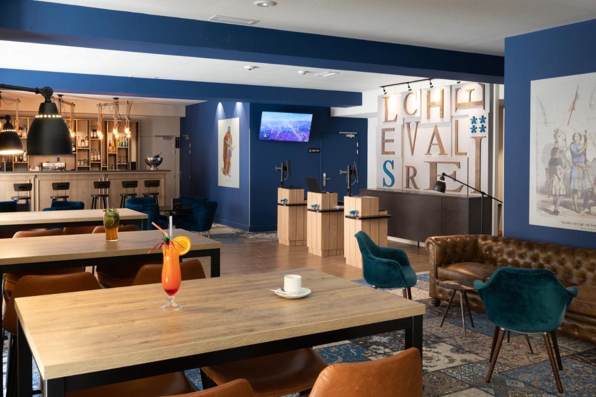 une salle à manger avec des murs bleus et une table et des chaises dans l'établissement SOWELL HOTELS Les Chevaliers, à Carcassonne