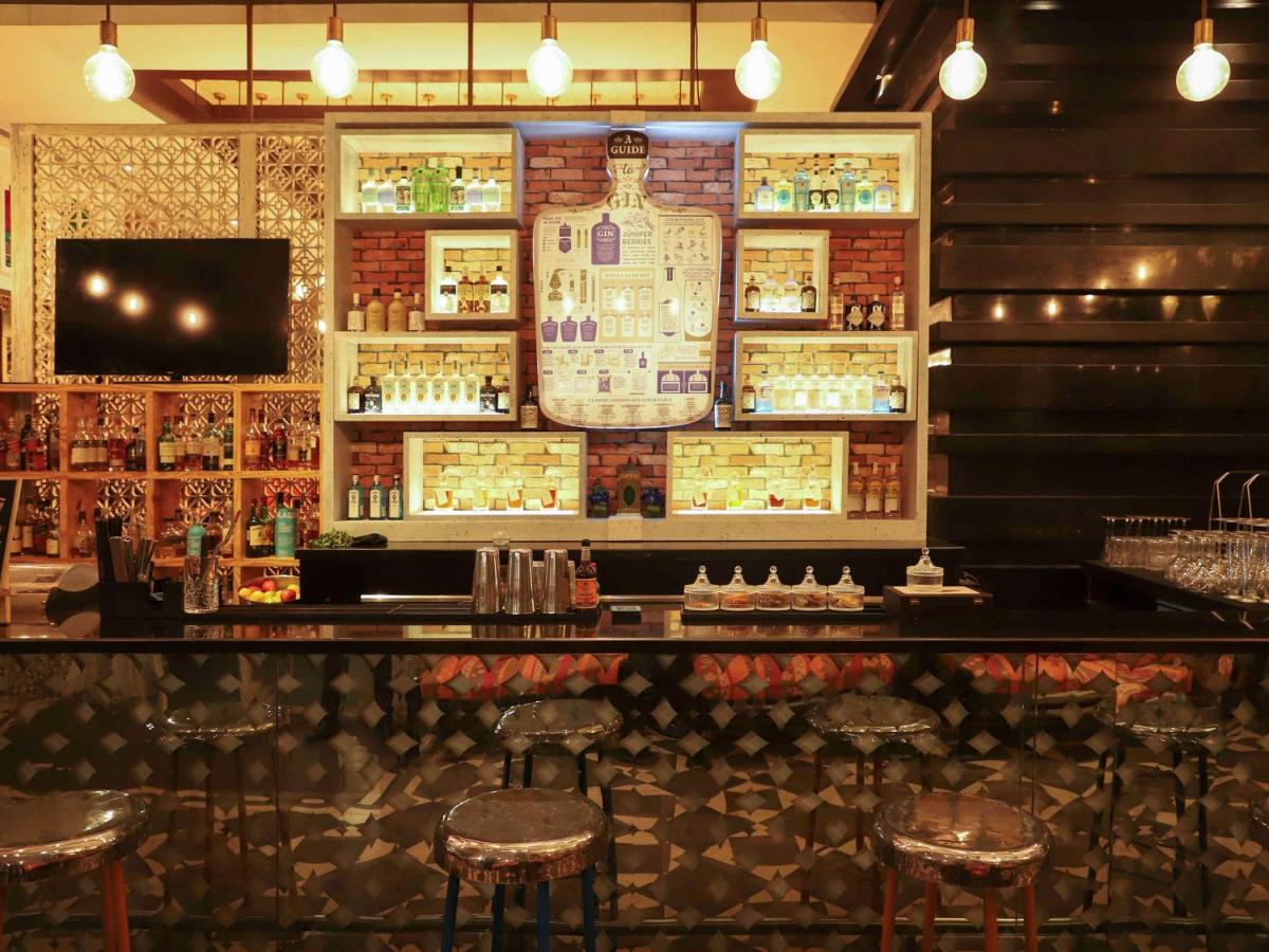 a bar with stools in front of a wall at Sofitel Mumbai BKC in Mumbai