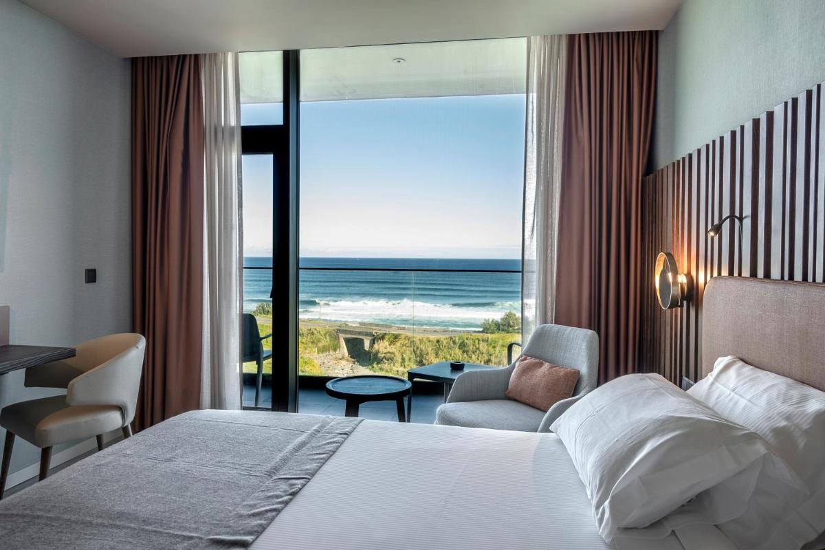 um quarto com uma cama e vista para o oceano em Hotel Verde Mar & SPA na Ribeira Grande mais 22 fotografias