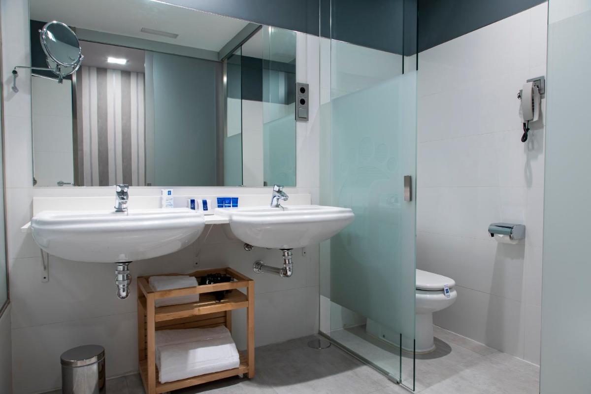 un baño con lavabo e inodoro en Hotel AR Isabel de Farnesio, en La Granja de San Ildefonso 30 fotos más