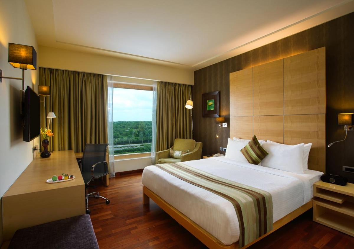 a hotel room with a large bed and a window at Novotel Hyderabad Airport in Hyderabad