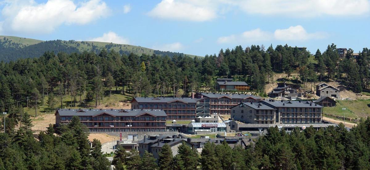 un grupo de edificios en una colina con árboles en Guitart La Molina Aparthotel & Spa, en La Molina un grupo de edificios en una colina con árboles en Guitart La Molina Aparthotel & Spa, en La Molina