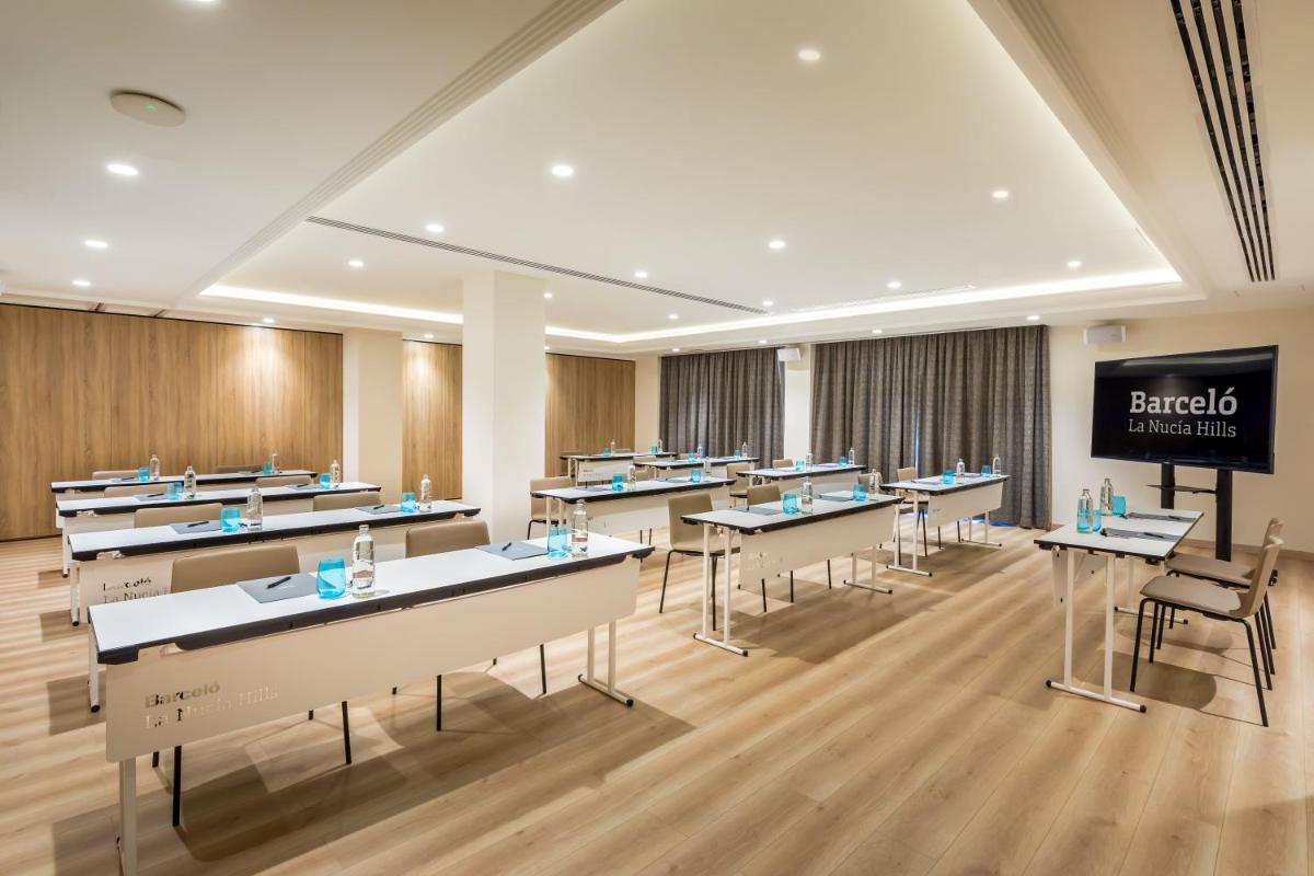 una clase con mesas, sillas y una pizarra en Barceló la Nucía Hills, en La Nucía