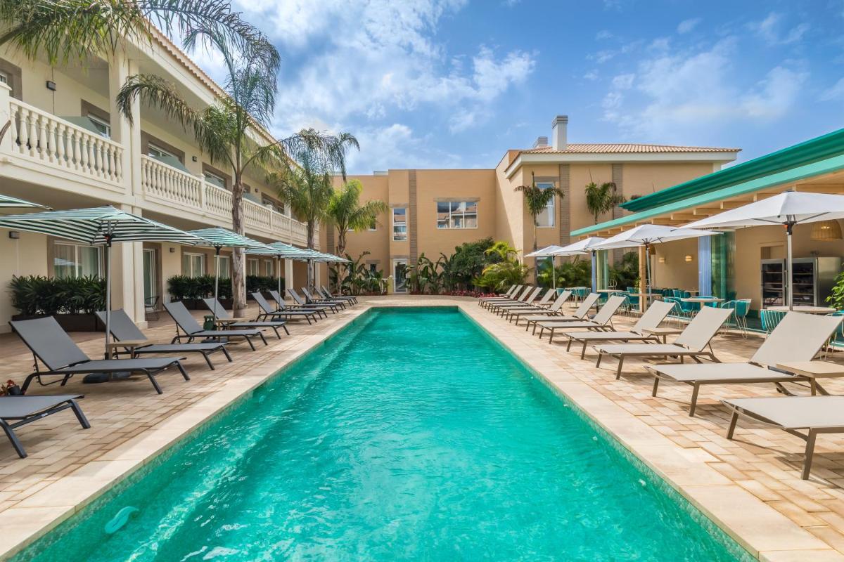 Una piscina con tumbonas y un resort. en Barceló La Nucía Palms, en La Nucía