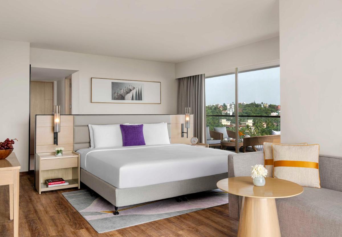 a hotel room with a bed and a couch at Vivanta Goa, Miramar in Panaji a hotel room with a bed and a couch at Vivanta Goa, Miramar in Panaji