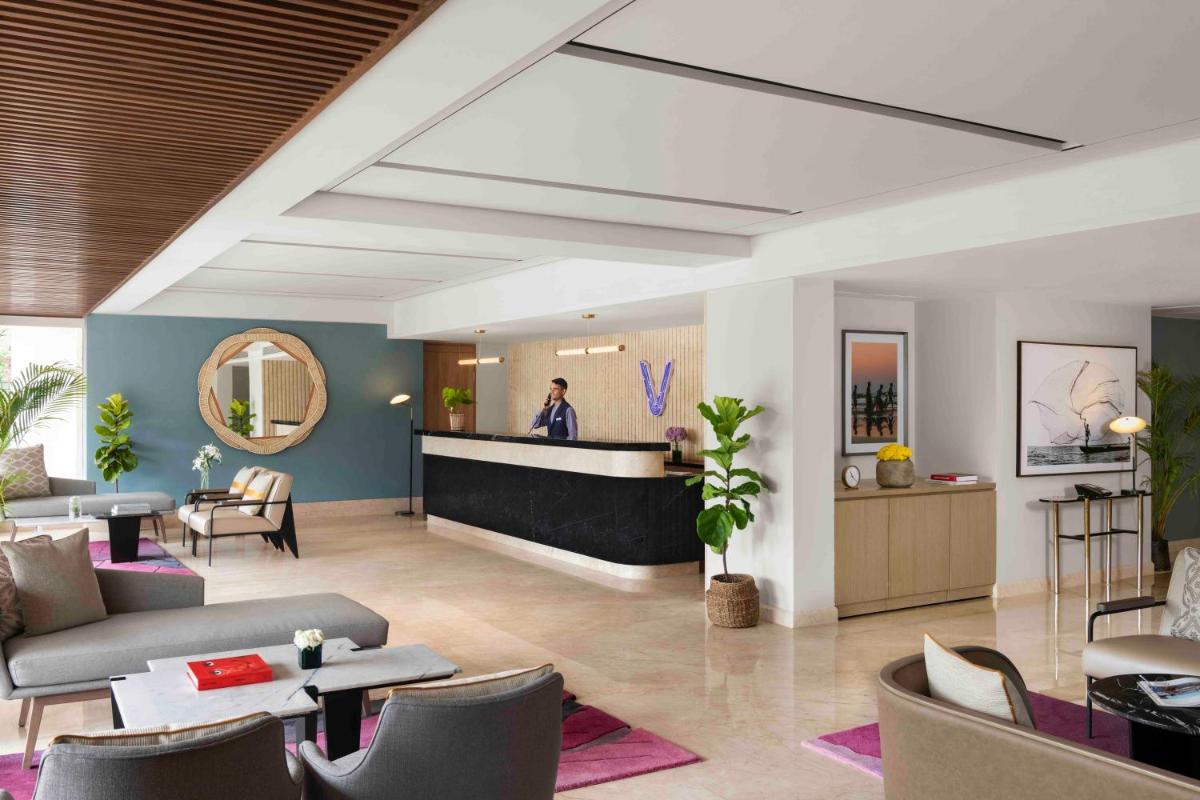 a lobby of a hotel with a reception desk at Vivanta Goa, Miramar in Panaji a lobby of a hotel with a reception desk at Vivanta Goa, Miramar in Panaji