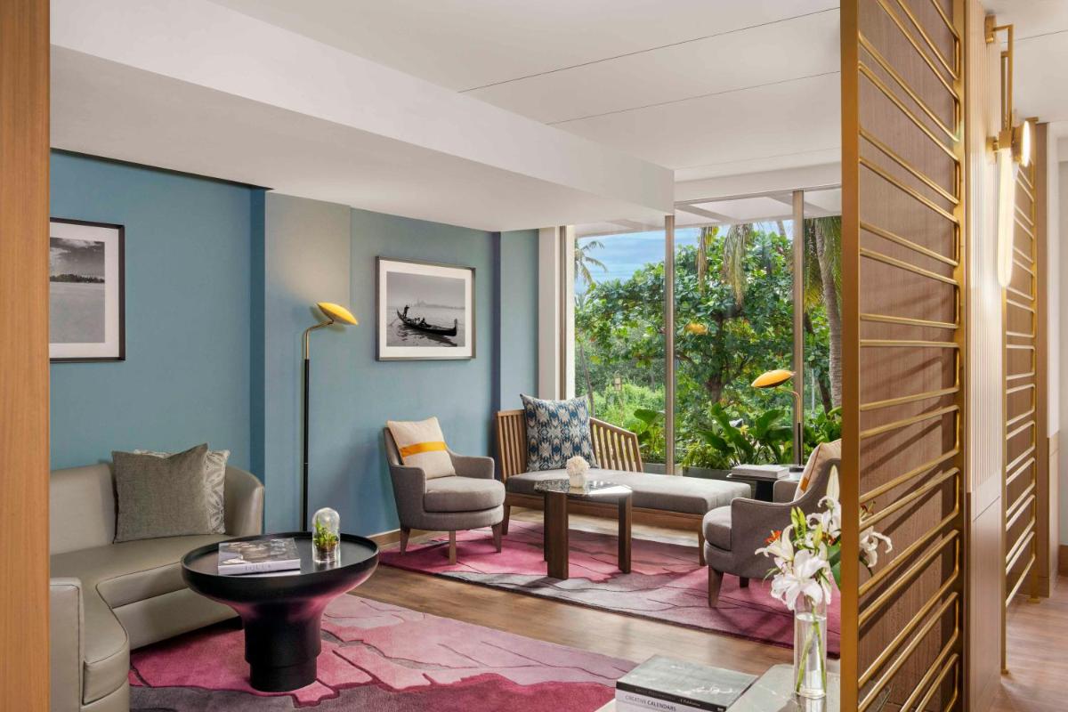 a living room with a couch and a table at Vivanta Goa, Miramar in Panaji a living room with a couch and a table at Vivanta Goa, Miramar in Panaji