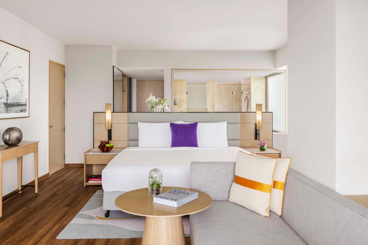 a hotel room with a bed and a couch at Vivanta Goa, Miramar in Panaji a hotel room with a bed and a couch at Vivanta Goa, Miramar in Panaji