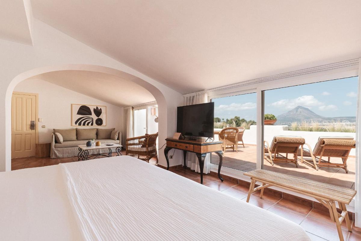 Un dormitorio con una cama y una ventana grande. en Hotel Ritual de Terra & SPA, en Jávea