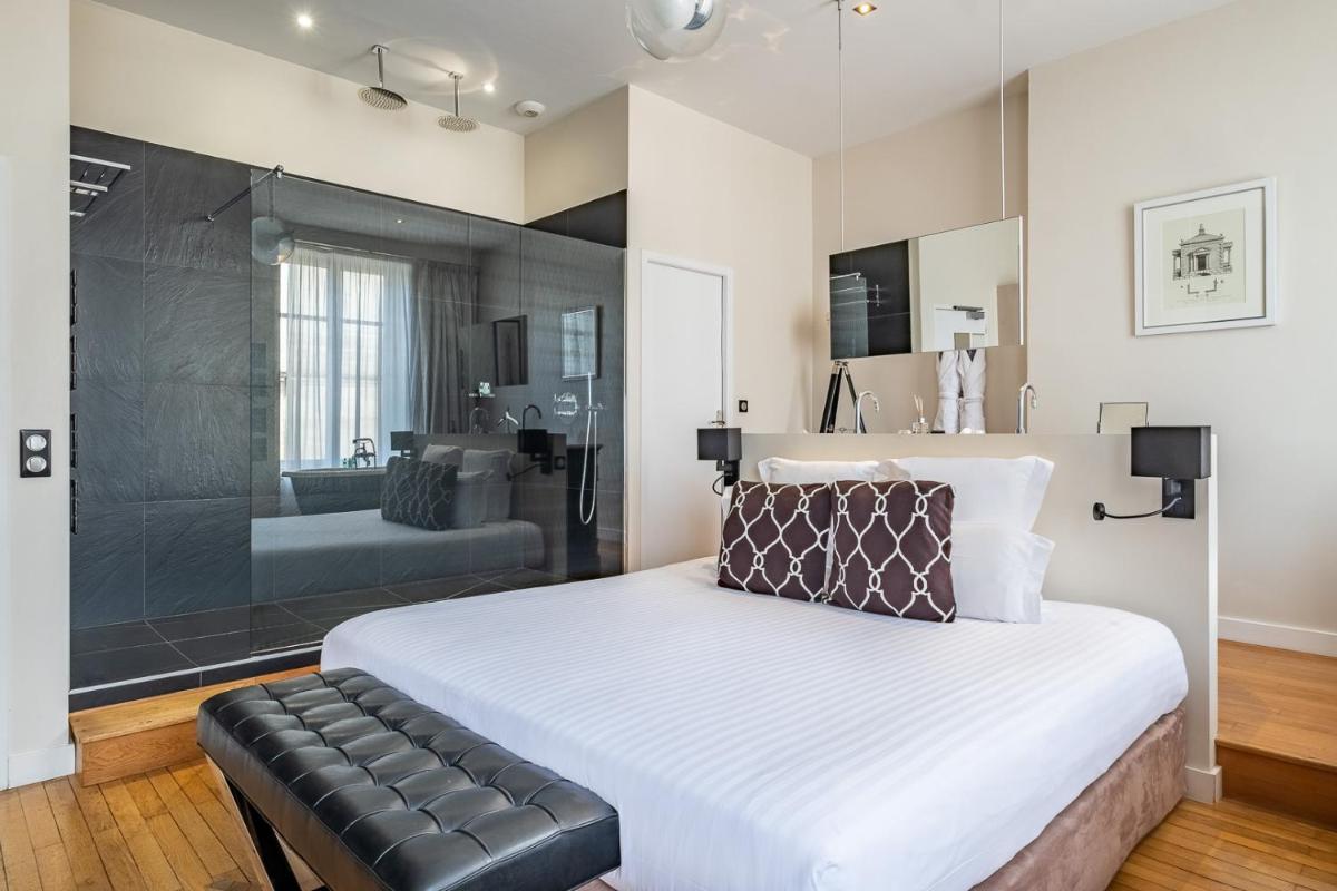 une chambre avec un grand lit et une salle de bain dans l'établissement Le Boutique Hotel & Spa, à Bordeaux