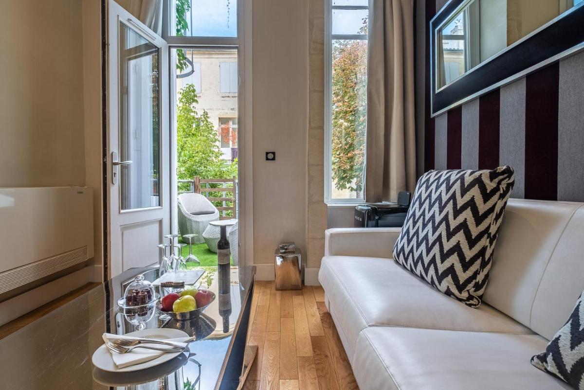 un salon avec un canapé et une table en verre dans l'établissement Le Boutique Hotel & Spa, à Bordeaux