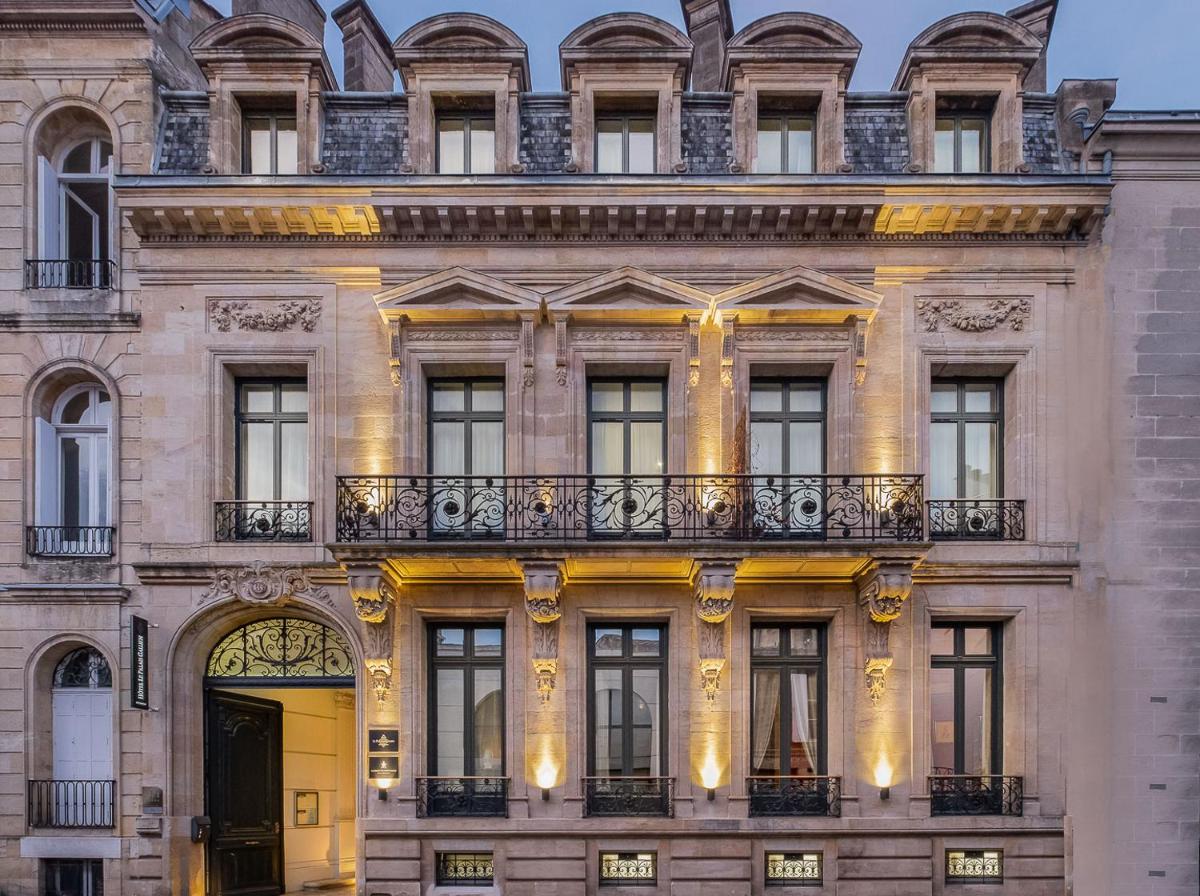 - un bâtiment avec une porte jaune et un balcon dans l'établissement Le Palais Gallien Hôtel & Spa, à Bordeaux
