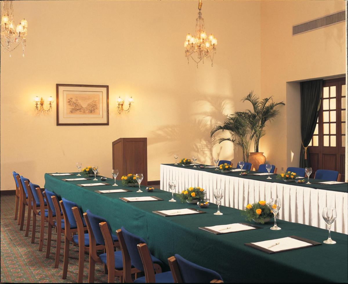 a long table in a room with chairs at Maidens Hotel New Delhi in New Delhi +51 photos