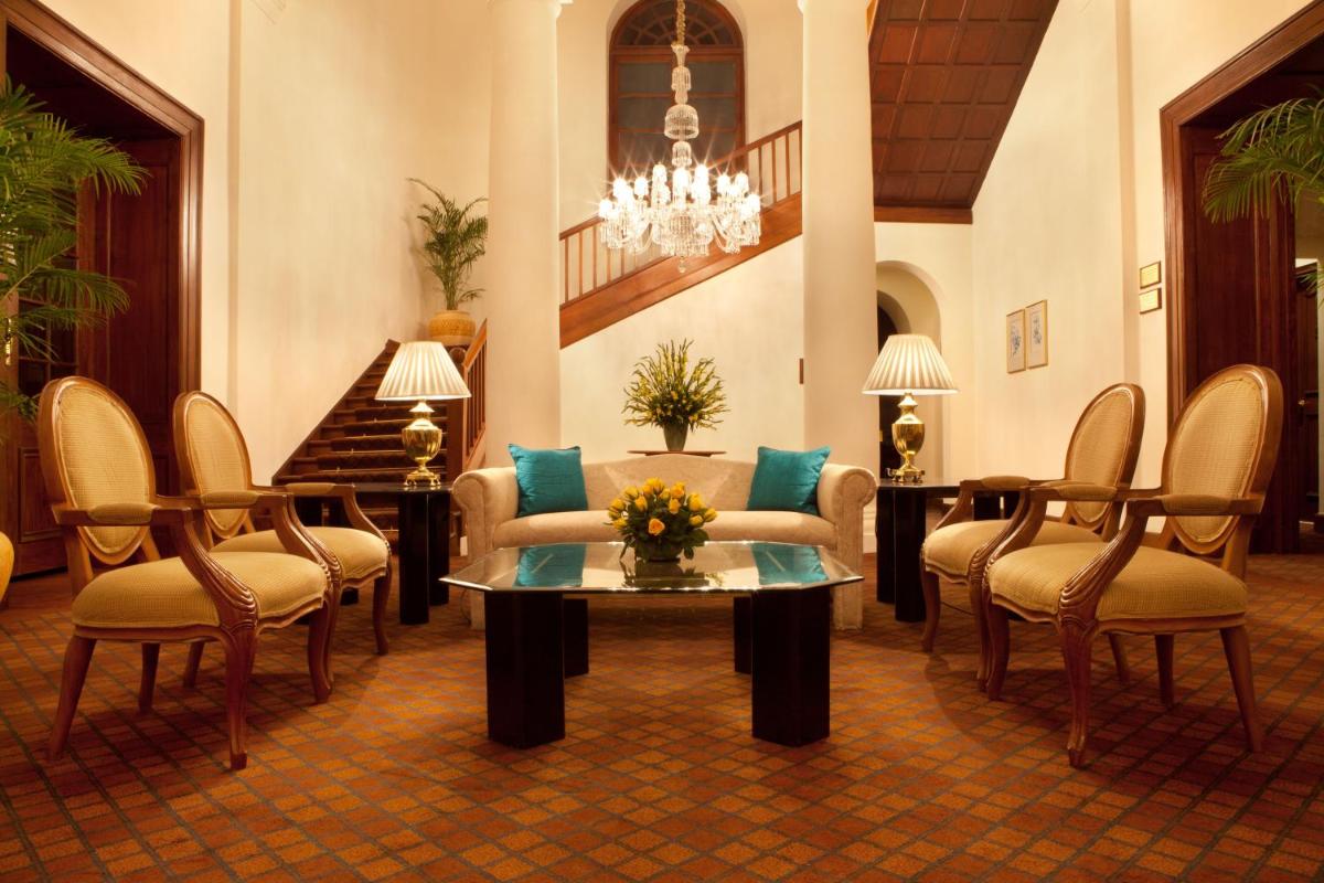 a lobby with a couch and chairs and a table at Maidens Hotel New Delhi in New Delhi
