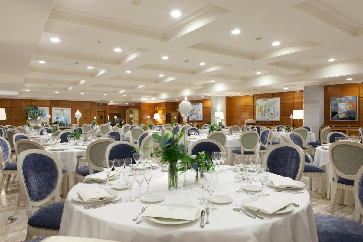 Un salón de banquetes con mesas y sillas blancas. en Hotel Carlos I Silgar, en Sanxenxo 77 fotos más