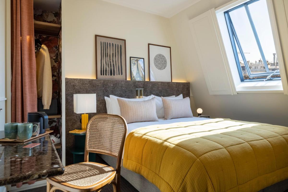 une chambre avec un grand lit et une fenêtre dans l'établissement Dadou Paris, à Paris