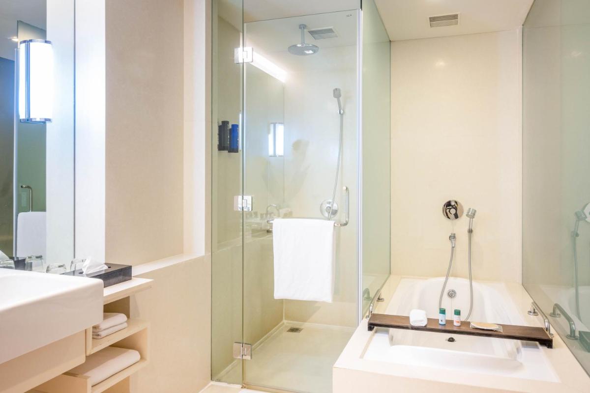 a bathroom with a shower and a sink at Novotel Hyderabad Airport in Hyderabad
