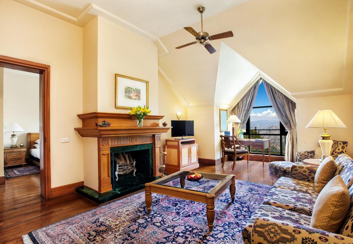 a living room with a fireplace and a couch at Wildflower Hall, An Oberoi Resort, Shimla in Shimla