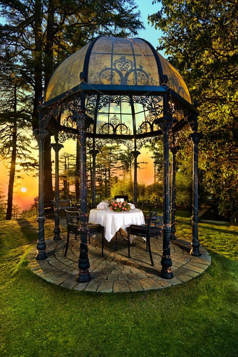 a gazebo with a table in the grass at Wildflower Hall, An Oberoi Resort, Shimla in Shimla