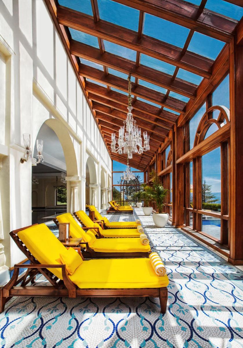 a row of yellow lounge chairs in a building at Wildflower Hall, An Oberoi Resort, Shimla in Shimla