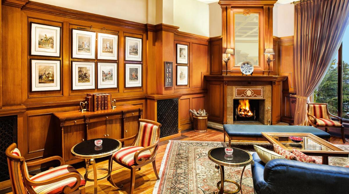 a living room with a fireplace and a couch at Wildflower Hall, An Oberoi Resort, Shimla in Shimla