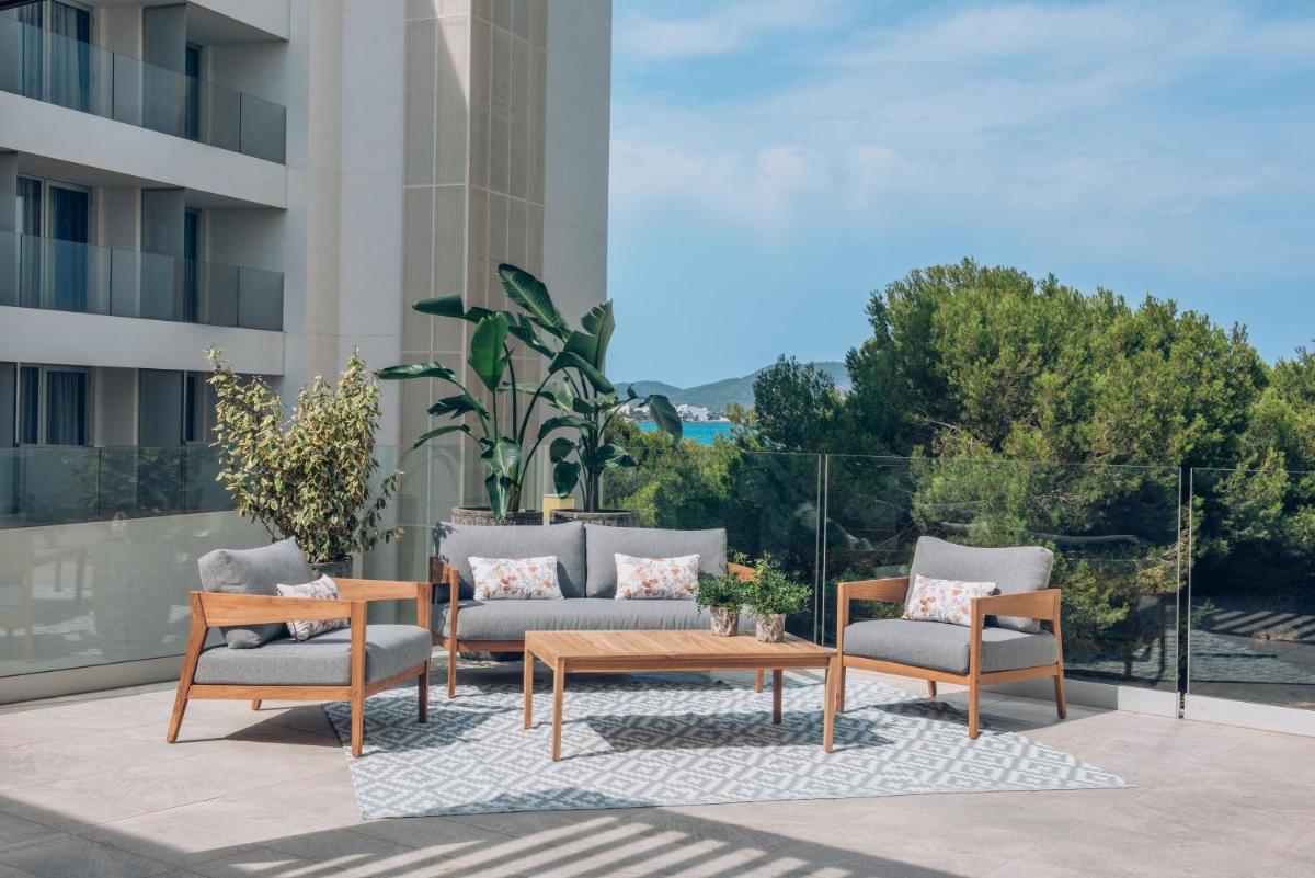 Un patio con un sofá y sillas y una mesa. en Iberostar Waves Cala Millor - Adults Only, en Cala Millor