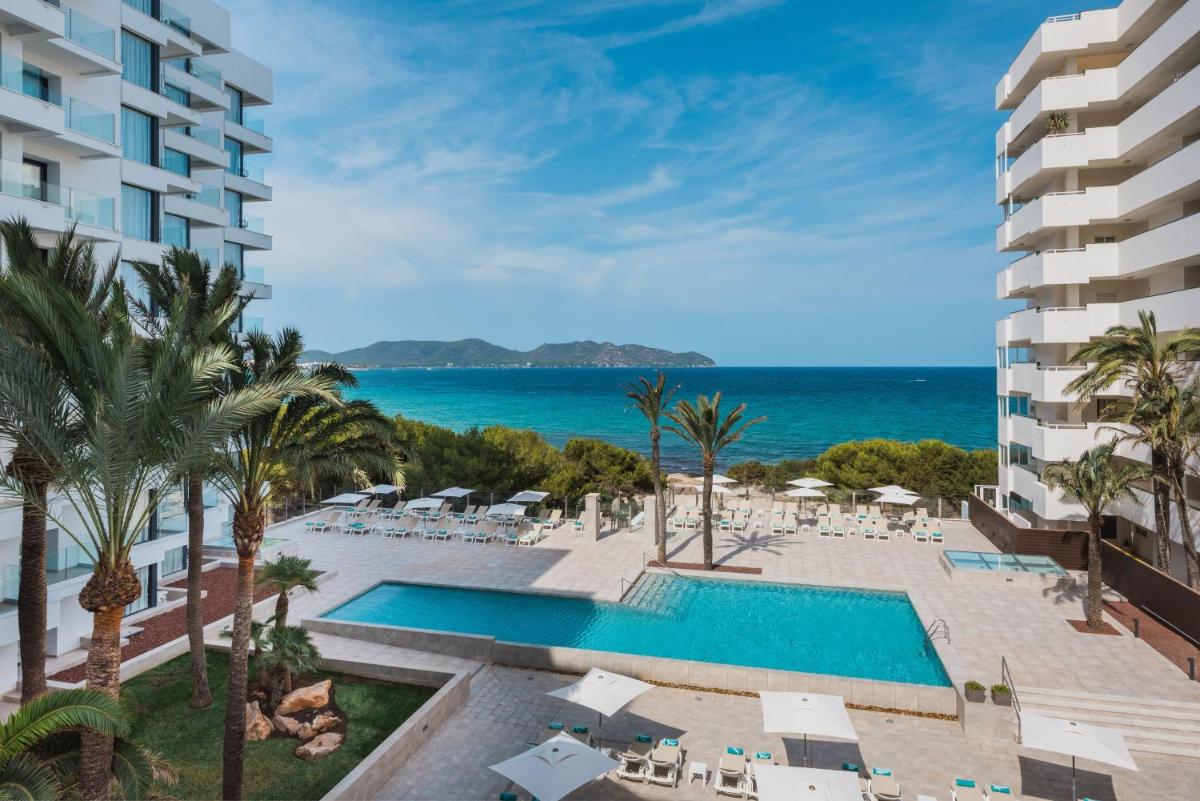 Una vista de la piscina y la playa del resort. en Iberostar Waves Cala Millor - Adults Only, en Cala Millor
