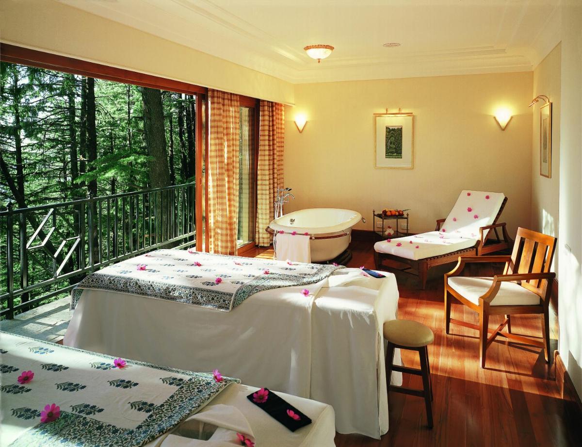a room with two beds and a balcony at Wildflower Hall, An Oberoi Resort, Shimla in Shimla