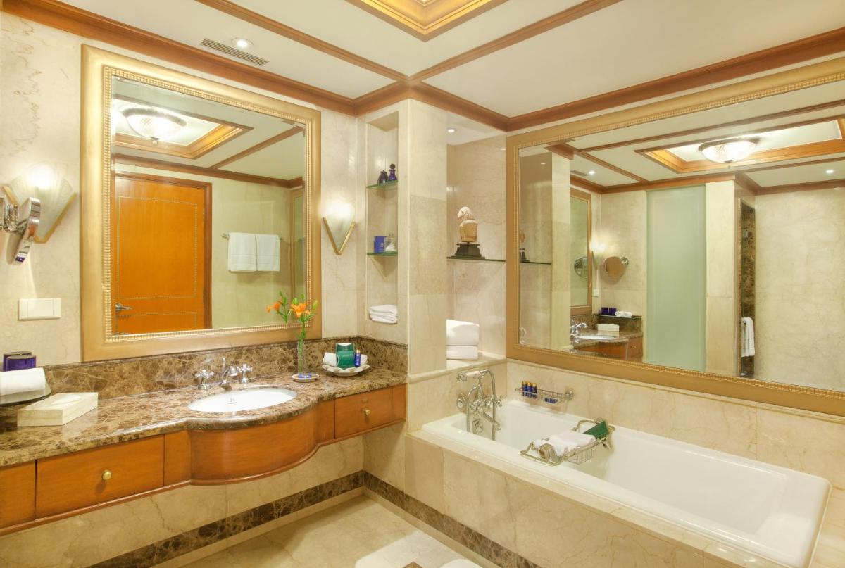 a bathroom with a tub and a sink and a mirror at Wildflower Hall, An Oberoi Resort, Shimla in Shimla