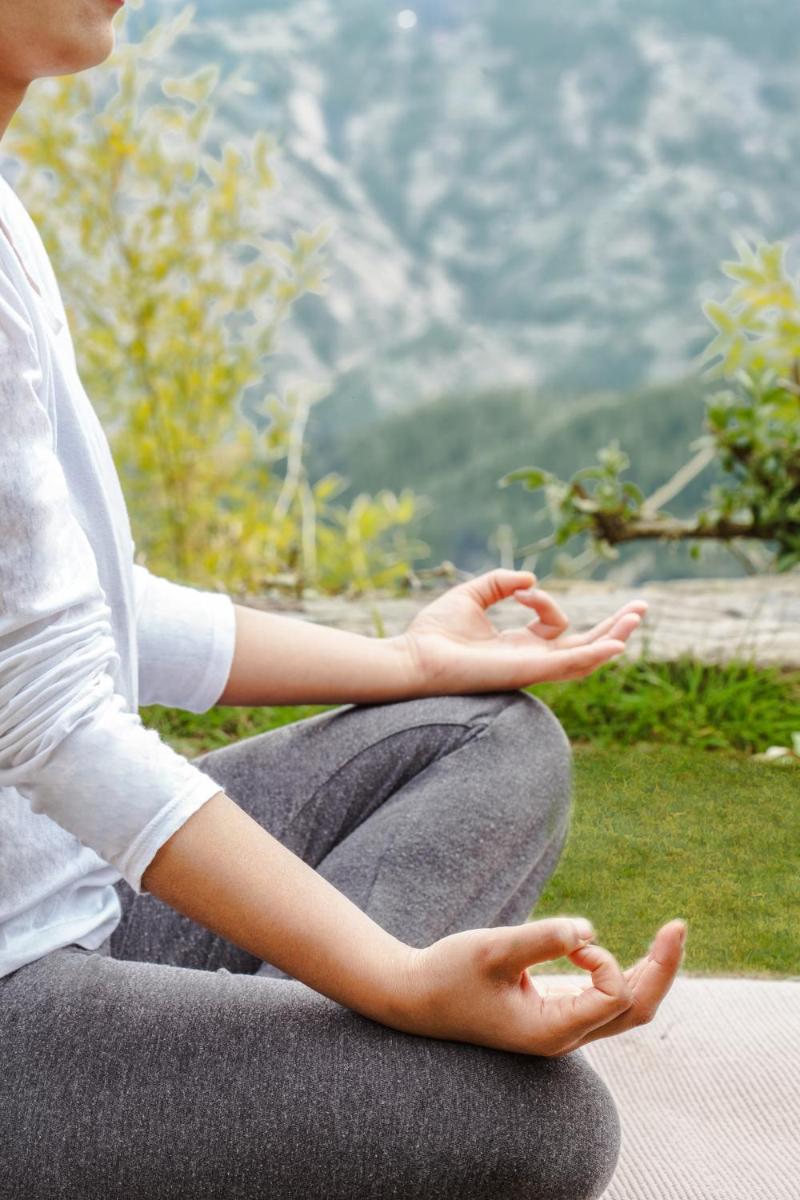 a woman sitting on the ground doing meditation at Wildflower Hall, An Oberoi Resort, Shimla in Shimla