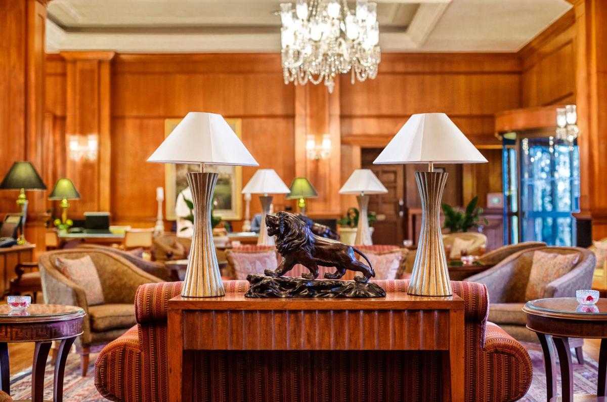 a lobby with a table with two lamps on it at Wildflower Hall, An Oberoi Resort, Shimla in Shimla